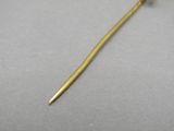 a close up of a gold stick with a flower on top of it