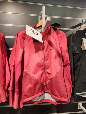 trois vestes suspendues à un portant dans un magasin