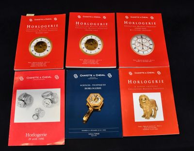 quatre livres posés sur une table, avec une horloge sur la couverture