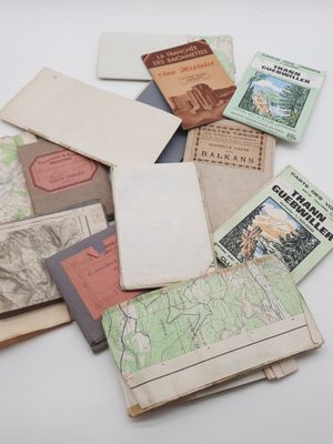 a pile of old maps and books on a table