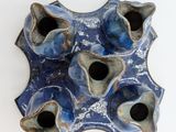 four blue vases that are sitting on a white surface