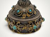 an ornate silver box with turquoise stones and gold accents