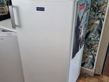 a small white refrigerator in the corner of a room