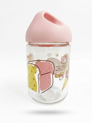 Le biberon a un bouchon rose et est orné d'un motif de dessin animé.