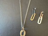 un ensemble composé d'un collier et de boucles d'oreilles, posé sur un fond en cuir noir