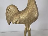 brass rooster figurine on stand on white background