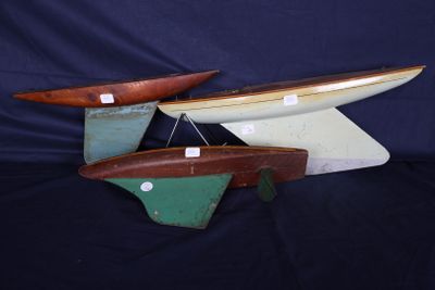 trois bateaux en bois exposés sur un fond noir