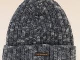 un gros plan d'un bonnet tricoté posé sur une surface blanche