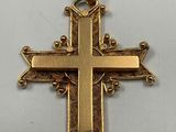 a close up of a gold cross on a white surface