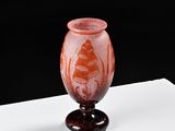 a red vase sitting on top of a white table