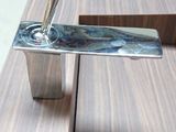 a metal faucet sitting on top of a wooden table