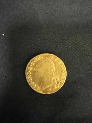 a close up of a gold coin on a black cloth