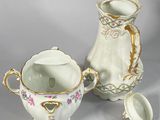 two vases and a cup sitting on a table