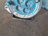 un tuyau bleu posé par terre à côté d'une poubelle