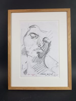 un dessin en noir et blanc représentant le visage d'une femme, dans un cadre en bois