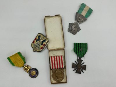 trois médailles et une médaille dans une boîte posée sur une surface blanche