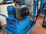 une machine bleue posée sur un chariot bleu dans un garage