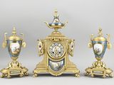 trois vases dorés et bleus et une horloge posés sur une table