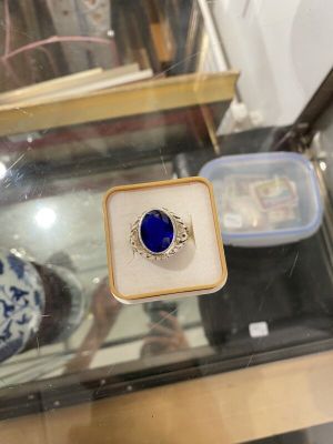 une bague sertie d'une pierre bleue, exposée dans une vitrine
