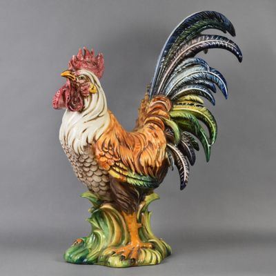 une statue représentant un coq posée sur un socle vert