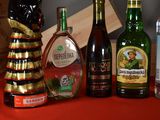 several bottles of alcohol are lined up on a red table