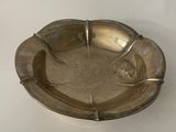 an old silver ashtray sitting on a white surface
