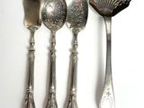 five spoons and a spoon with a shell on them