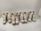 Plusieurs paires de chaussures sont alignées sur une surface blanche
