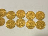 a bunch of gold coins sitting on top of a white surface