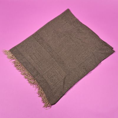 une écharpe marron à franges sur fond rose