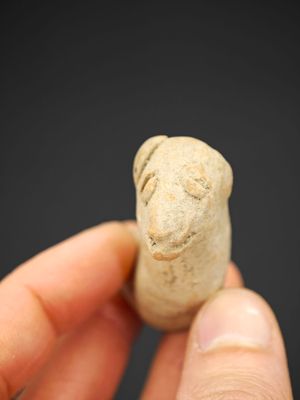 une personne tient un petit objet dans la main, sur un fond noir