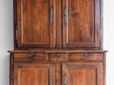 an old wooden cabinet with two doors and a drawer underneath it