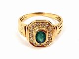 a close up of a gold ring with a green stone