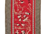un tapis rouge orné d'oiseaux et de fleurs