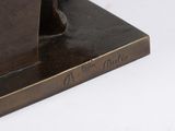 a bronze statue of a man with a hat on it ' s head