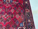 a large red rug with many different designs on it