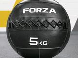 a black medicine ball sitting on the floor in a gym