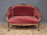 an image of a red couch sitting on top of a wooden floor
