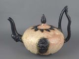 a black and white teapot on a gray surface