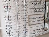 many glasses on display in a store with a mirror