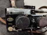 an old camera sitting on a table next to a bag