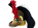 a gold helmet with a red feather on top of it