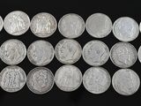 a bunch of silver coins sitting on top of a black surface