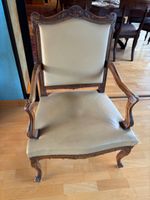 Un fauteuil à la reine en bois sculpté à décor de feuillages…