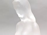 a white sculpture of a woman standing on top of a table