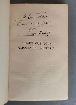 un livre ouvert avec une écriture manuscrite posé sur une table