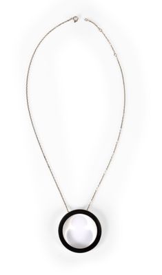 un collier noir et blanc avec un pendentif circulaire monté sur une chaîne