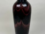 un vase noir orné d'un motif en spirale rouge
