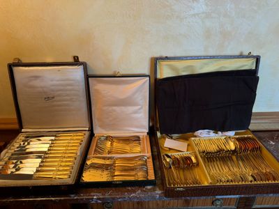deux valises contenant de l'argenterie, posées sur une table