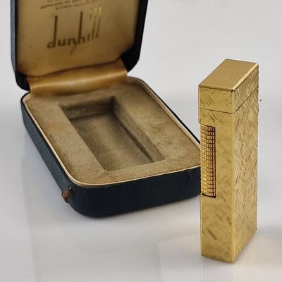 un briquet doré posé à côté d'un étui noir sur une table